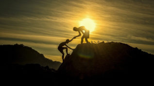 一个人帮助另一个人爬山