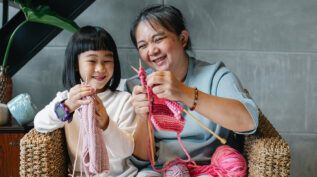 年轻的孩子和祖母编织-吸引下一代