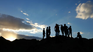 一群人在山顶部在日落